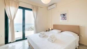 A hotel room with a bed, a view of the sea, and an air conditioning unit on the wall. - Villa in Pera Melana Near Kissakas Beach (South Kynouria)