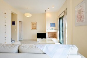 Relax in this stylish living room with a sofa, flat-screen TV, and fireplace.