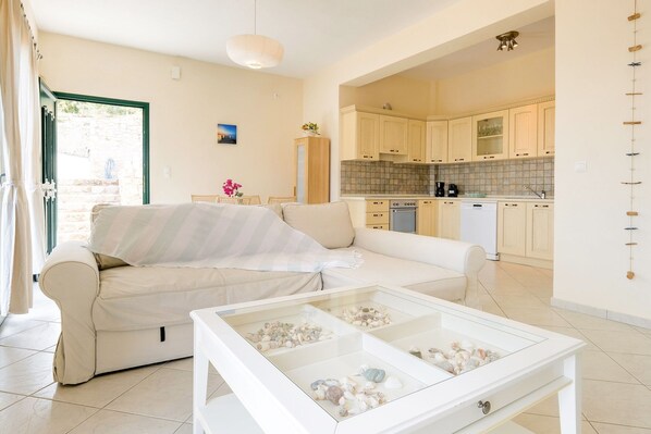 Relax in this stylish living room with a sofa, coffee table, and kitchen area.