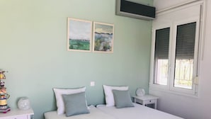 A bedroom with a bed, two pillows, a bedside table with a lamp, and two framed pictures on the wall. - Luxurious Villa in Peloponnese (Pylos-Nestoras)