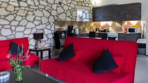 Ein modernes Wohnzimmer mit einem roten Sofa und einer Steinwand.