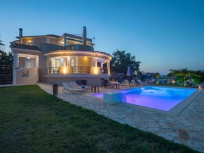 A modern house with a swimming pool, outdoor seating, and a well-lit patio area. - Villa in Kalpaki With Private Pool (Zakynthos)