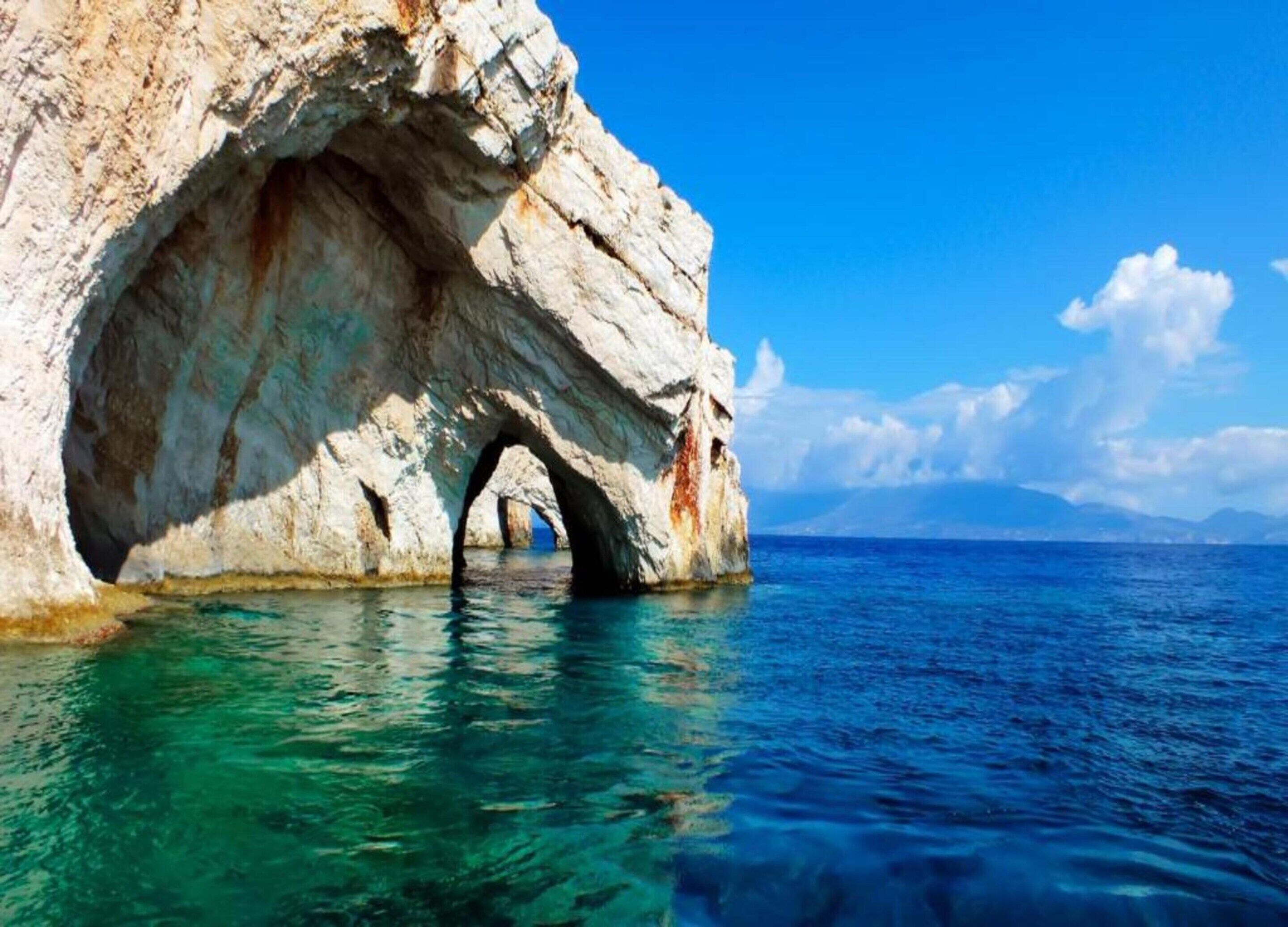 A natural rock formation with a cave-like opening in the sea.