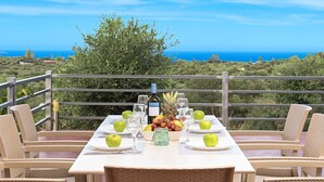 A table set for two with a scenic view of the ocean and hills. - Modern Villa With Heated Swimming Pool in Georgioupoli Greece (Apokoronas)