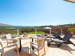 A terrace with a table set for breakfast, overlooking a scenic view of the sea and hills. - 3 Villas Next to Each Other with Pool & Sea View (Apokoronas)