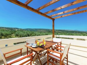 A wooden table and chairs on a balcony with a clear view of a hilly landscape. - Villa with Private Pool near Sea & Arkadi Monastery on NW Coast (Rethymno)