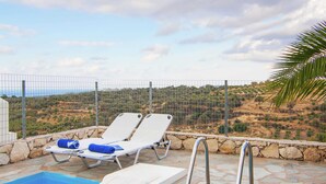 A pool area with two sun loungers and a pool ladder. - Spacious Villa in Arkadi with Swimming Pool near Sea (Rethymno)