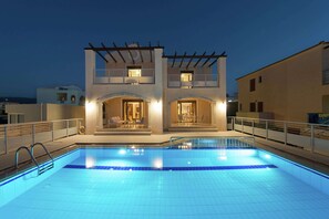 A two-story building with a swimming pool in front.