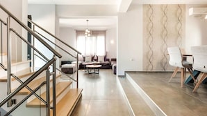A modern living room with a staircase, a sofa set, and a dining area with chairs. - Beautiful new Large House, Private Pool, Near Beach at Rethymno, NW Coast (Rethymno)