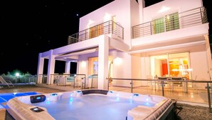 Een modern gebouw met twee verdiepingen, een jacuzzi en een terras.
