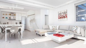 A modern living room with a sofa, coffee table, and dining area. - Villa in Rhodes With Infinity Pool & BBQ (Rhodes)