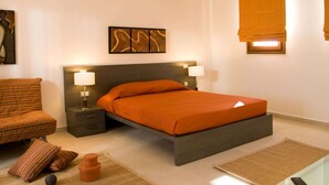 Ein modernes Schlafzimmer mit einem Bett, zwei Nachttischen, einem Sessel und einem Teppich.