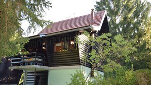 A log cabin with a balcony, surrounded by trees and greenery. - Restful Holiday Home in Vrbovsko (Vrbovsko)