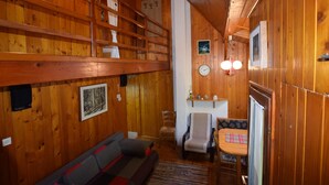 A wooden cabin interior with a sofa, a dining table, and a chair. - Restful Holiday Home in Vrbovsko (Vrbovsko)