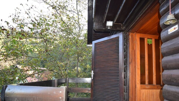A log cabin with a wooden door, a metal gate, and a tiled patio area. - Restful Holiday Home in Vrbovsko (Vrbovsko)