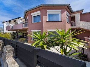 Relax on the upper-level balcony with a view of lush greenery.
