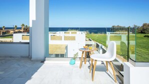 A balcony with a clear view of the sea, a white chair, a small table with a drink, and a glass railing. - Luxury Villa, Private Pool & Beach, Pigianos Kampos, Rethymno Area, NW Coast (Rethymno)