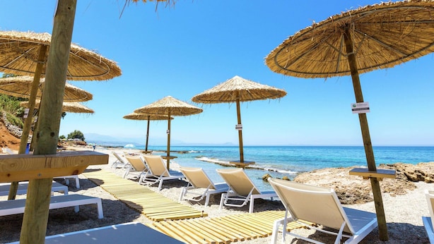 A beach with wooden lounge chairs and straw umbrellas. - Luxury Villa, Private Pool & Beach, Pigianos Kampos, Rethymno Area, NW Coast (Rethymno)