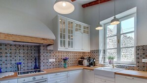 A kitchen with white cabinets, a tiled backsplash, a wooden countertop, a built-in oven, and a window with a view of the outside. - Holiday Home in Osor Near Sandy Beach (Mali Losinj)