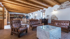A spacious living room with leather sofas, a glass coffee table, and wooden flooring. - Villa in Sukosan With Pool Near the Sea (Sukosan)