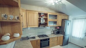 A modern kitchen with wooden cabinets, a stainless steel refrigerator, a microwave, and a sink. - Holiday Home in Imotski With Pool (Imotski)