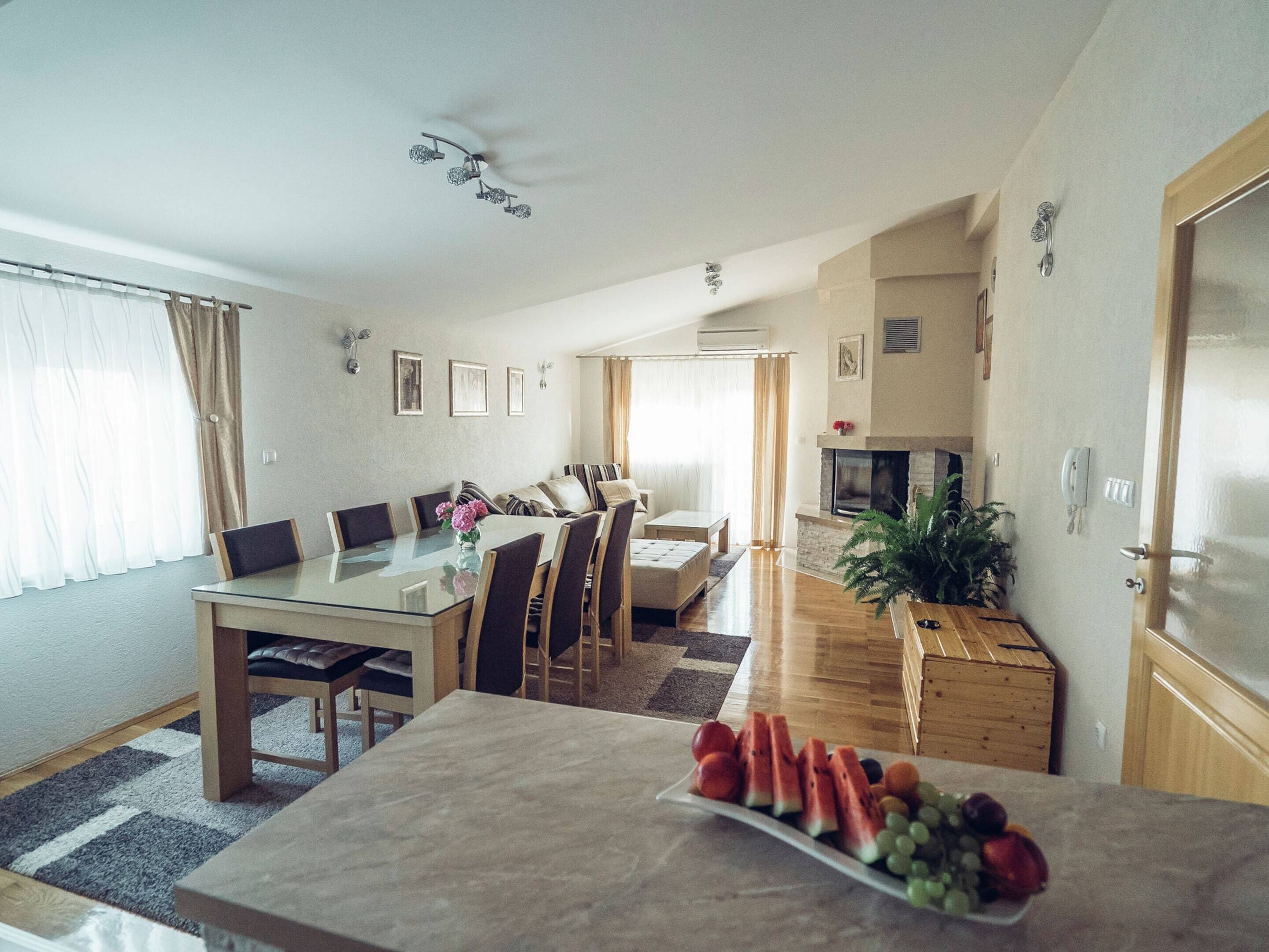 Ein modernes Wohnzimmer mit Essbereich, Kamin und Küche.