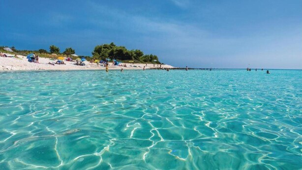 A beach with clear turquoise water and white sand.