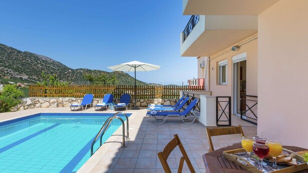 A poolside area with lounge chairs and a table with breakfast items. - Hillside Villa in Bali With Private Pool (Mylopotamos)