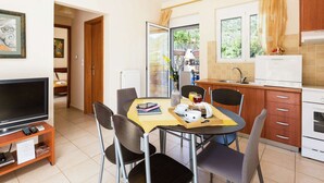 A compact kitchen with a dining area, a TV, and a view of the outdoors. - Hillside Villa in Bali With Private Pool (Mylopotamos)