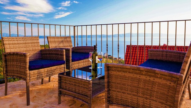 Wicker chairs with cushions on a balcony with a view of the sea. - Villa in Podgora With Pool Near Beach (Podgora)