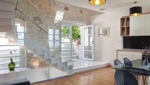 A modern kitchen with a glass dining table, black chairs, and a wooden countertop. - Villa in Podgora With Pool Near Beach (Podgora)