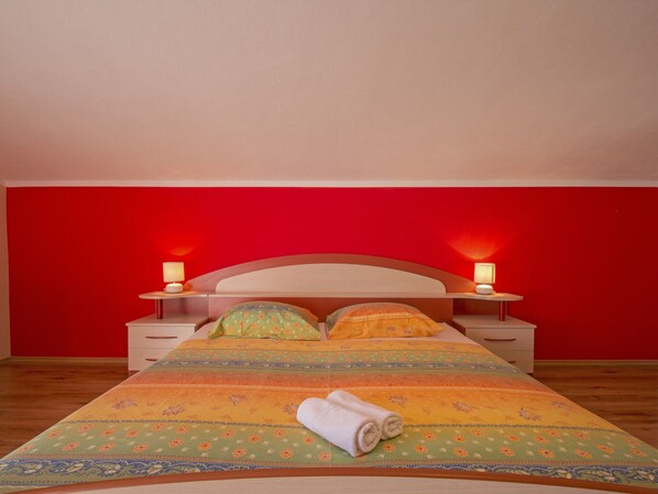 A bed with a floral bedspread, two bedside lamps, and a rolled towel on the bed. - Adorable Holiday Home With Private Pool & Terrace With Barbecue (Vinodol)