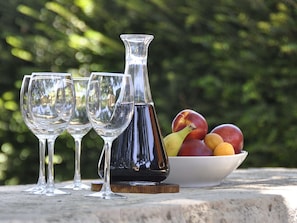 Three wine glasses and a decanter on a table with a bowl of fruit in the background. - Adorable Holiday Home With Private Swimming Pool & Terrace (Visnjan)