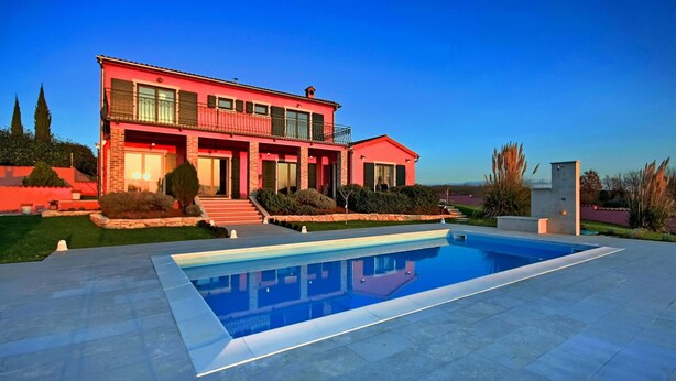A two-story house with a swimming pool in front.