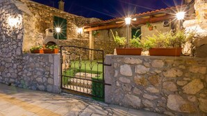 A stone-walled building with a tiled roof, a gated entrance, and potted plants. - Large Holiday Home With Private Pool, Wellness & Sea View (Vinodol)