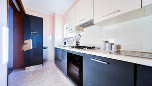 Une cuisine moderne avec des meubles de couleur sombre, un plan de travail blanc et un four encastré.