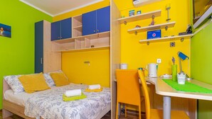 A room with a bed, a chair, a table, and a shelf with various items. - Studio Apartment With Swimming Pool & Sea View (Crikvenica)