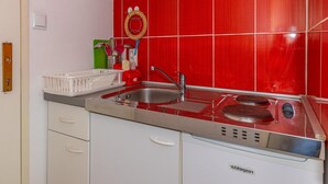 A kitchen with red tiles, a stainless steel sink, and a built-in stove. - Studio Apartment With Swimming Pool & Sea View (Crikvenica)