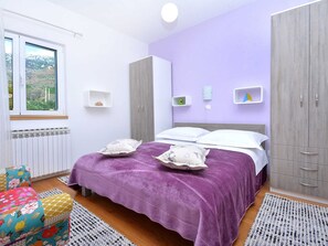 Quarto com cama, guarda-roupa e janela com vista.