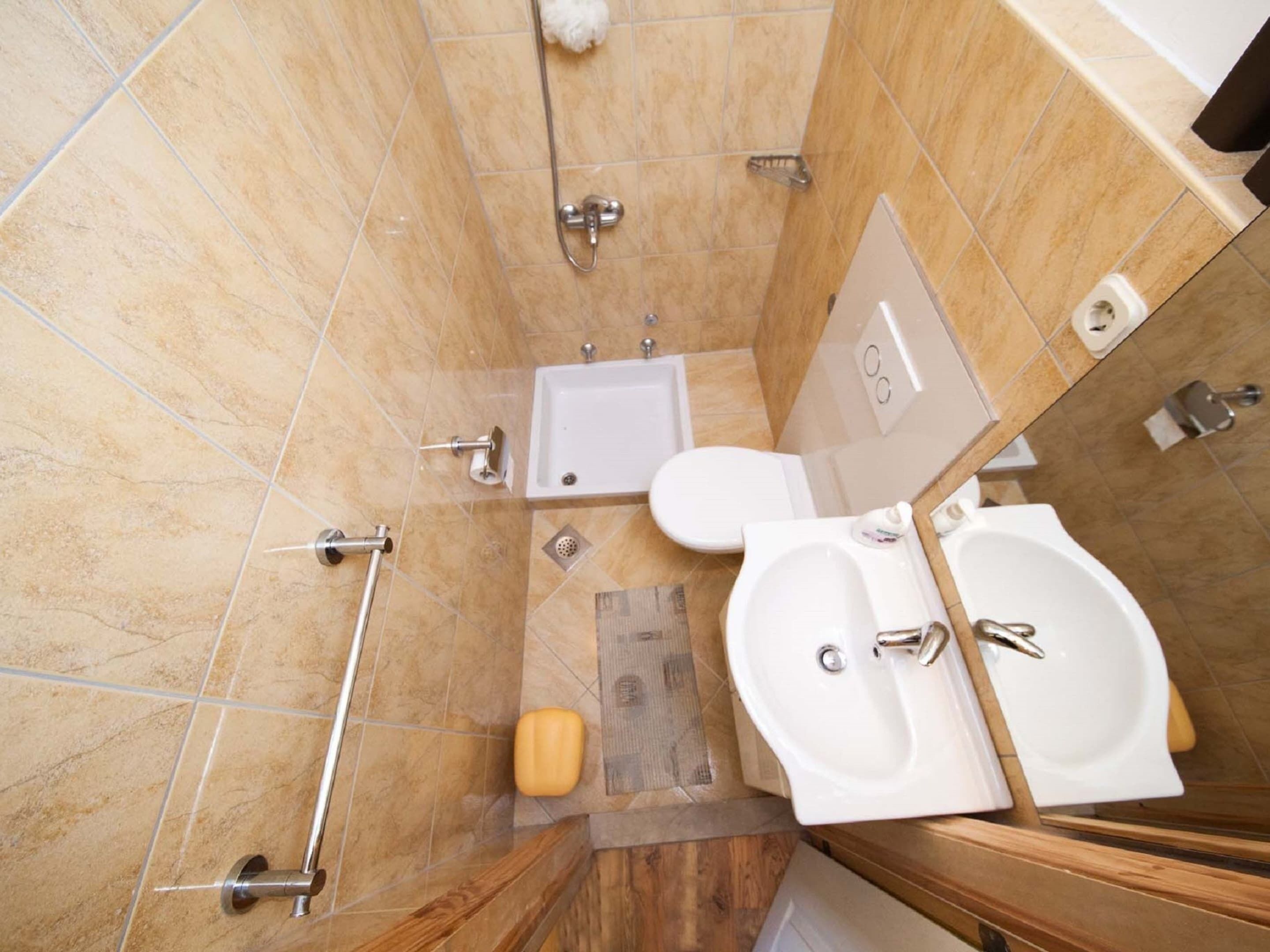 A modern bathroom with a shower, toilet, bidet, and sink.
