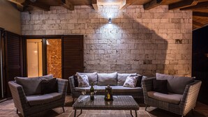 A cozy outdoor seating area with wicker furniture, a table with drinks, and a brick wall backdrop. - Charming Villa With Private Pool (Drnis)