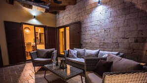 An outdoor seating area with wicker furniture and a glass table, featuring a brick wall and wooden shutters. - Charming Villa With Private Pool (Drnis)