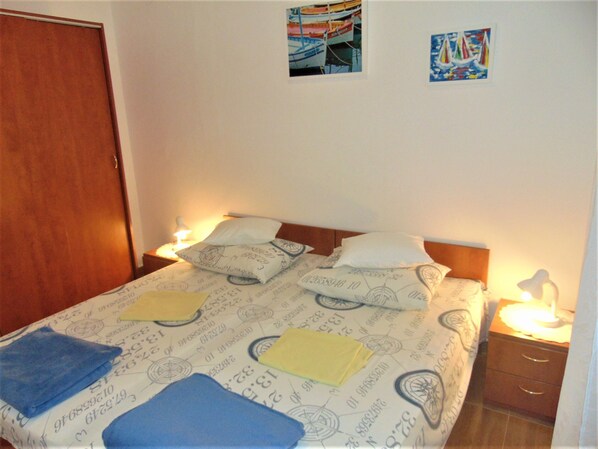 A bedroom with a bed, two bedside tables, a wooden headboard, and two wall-mounted pictures. - Amazing 2 Storey Holiday Home With 120m Roof Terrace, Directly on the Beach (Sveti Filip i Jakov)