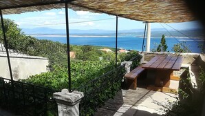 A terrace with a view of the sea, a wooden bench, and a stone balustrade. - Spacious Holiday Home With Terrace & Great Sea View (Crikvenica)