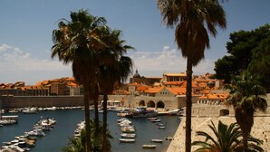 A coastal town with a historic harbor, stone walls, and palm trees. - Spacious Apartment, Private Terrace in the Countryside, Wi-fi and Parking (Konavle)