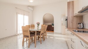 A modern kitchen with white cabinets, a wooden countertop, and a built-in oven. - Apartment in Vrsi Near the Sea (Vrsi)