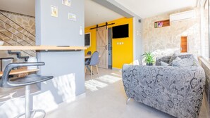 Un espacio de estar moderno con comedor, sofá y escalera.