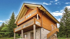A two-story wooden house with a balcony, a stone foundation, and a staircase leading to the upper level. - Holiday Home Ravna Gora Near Risnjak Park (Ravna Gora)