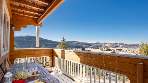 A wooden deck with a table set for outdoor dining, overlooking a scenic mountain landscape. - Holiday Home Ravna Gora Near Risnjak Park (Ravna Gora)