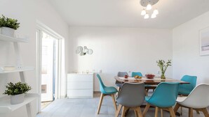 A modern dining area with a white table, teal chairs, and a ceiling light fixture. - Maslenica Pool Villa With Charm (Jasenice)
